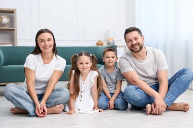 Ebeveynler ve çocukları evde sıcak zeminde birlikte. Isıtma sistemi