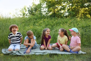 Çocuklar yaz günü doğada vakit geçirirler.