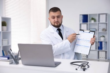 Klinikte bilgisayarla online danışmanlık yapan bir doktor
