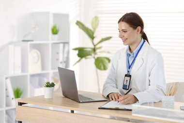 Teletıp. Doktor içeride bilgisayarla hastayla görüntülü konuşma yaparken not alıyor.