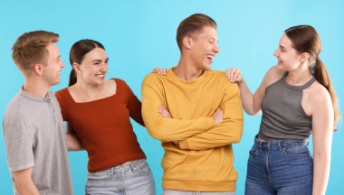 Açık mavi arka planda gülen arkadaşlar. Pozitif duygu