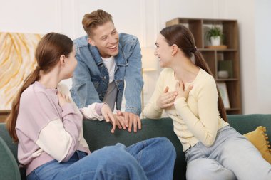 Arkadaşlar kanepede gülüyor. Pozitif duygu