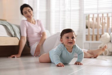 Anne kucuk sevimli bebegi evde yerde, seçici bir odaği var.