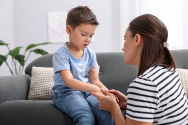 Anne evdeki kanepede üzgün oğlunu destekliyor.