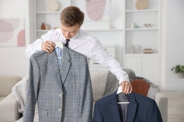 Hazırlanıyor. Genç adam evde kıyafet seçiyor.