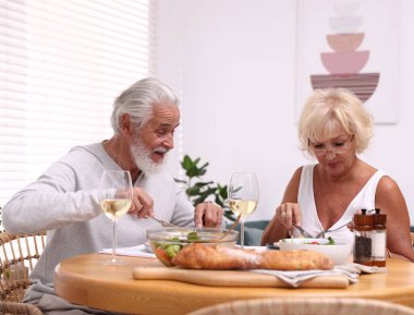 Evde yemek yiyen yaşlı bir çift.