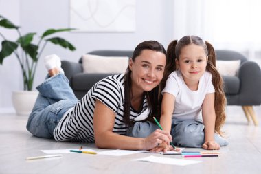 Anne ve kızı evdeki sıcak zeminde birlikte resim çiziyorlar. Isıtma sistemi