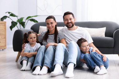 Ebeveynler ve çocukları evde sıcak zeminde birlikte. Isıtma sistemi