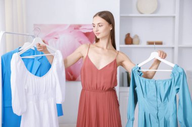 Hazırlanıyor. Evde kıyafet seçen genç bir kadın.