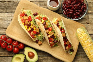 Lezzetli vejetaryen takolar ve malzemeler ahşap masada, düz yerde.