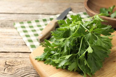 Bir demet taze maydanoz ve bıçak ahşap masada, yakın plan.