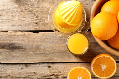 Lezzetli portakal suyu, taze meyve suyu ve meyve sıkacağı ahşap masada, düz yerde. Metin için boşluk