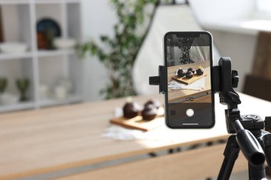Stüdyoda akıllı telefonlu çikolatalı kek çekmek, seçici odaklanma. Profesyonel yemek fotoğrafçılığı.