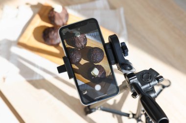 Stüdyoda akıllı telefonla çikolatalı kek çekmek. Profesyonel yemek fotoğrafçılığı.
