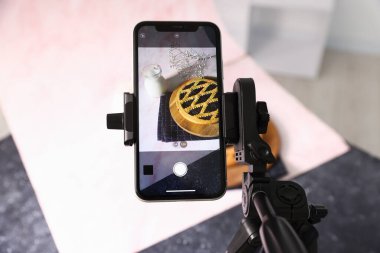 Stüdyoda lezzetli turta ve sütle akıllı telefon çekmek. Profesyonel yemek fotoğrafçılığı.