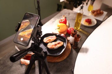Stüdyoda güzel kızarmış balık ve akıllı telefon çekmek. Profesyonel yemek fotoğrafçılığı.