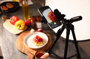 Stüdyoda akıllı telefonla lezzetli makarna çekmek, seçici odaklanma. Profesyonel yemek fotoğrafçılığı.