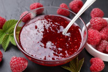 Cam kasede tatlı ahududu reçeli ve gri masada böğürtlen, yakın plan.