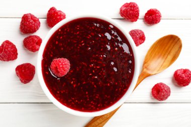 Tatlı ahududu reçeli kasede ve böğürtlen beyaz ahşap masada, düz yatıyordu.