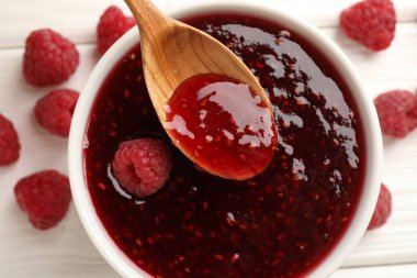 Beyaz masada kaseden kaşıkla ahududu reçeli alıyorum.