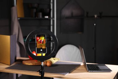 Stüdyoda akıllı telefonla sebze çekmek, ekrana odaklanmak. Profesyonel yemek fotoğrafçılığı.