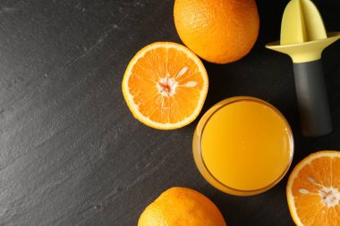 Bardakta taze portakal suyu, siyah masada meyve suyu ve meyve sıkacağı. Metin için boşluk