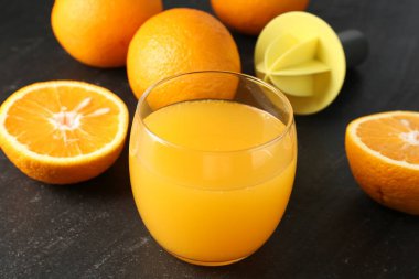 Bardakta taze portakal suyu, siyah masada meyve suyu, yakın plan.