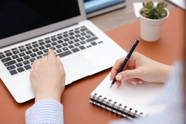 Masada dizüstü bilgisayarda yazan metin yazarı, yakın plan.