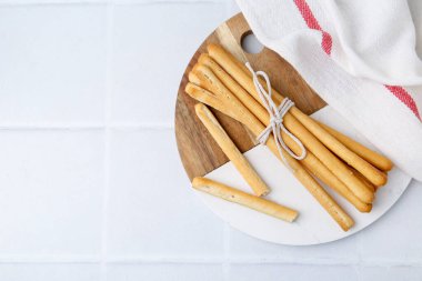 Lezzetli Grissini beyaz fayanslı masaya yapışıyor. Metin için boşluk