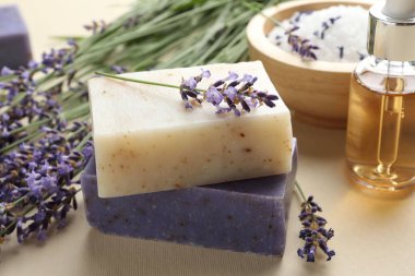Aromatik sabun barları ve bej arka planda lavanta çiçekleri, yakın plan.