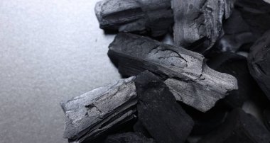 Masanın üstünde siyah kömür parçaları var. Metin için boşluk