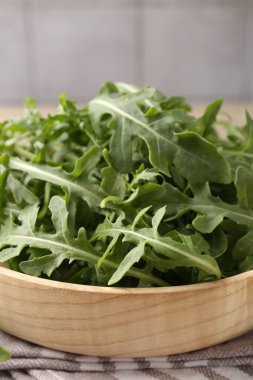 Taze yeşil roka yaprakları açık ahşap masada, yakın plan.