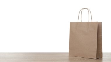 Tahta masada beyaz arkaplana karşı bir kese kağıdı.