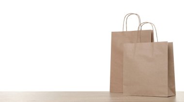 Tahta masada beyaz arka planda iki kese kağıdı var.