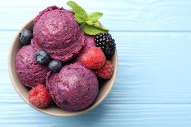 Taze böğürtlenli lezzetli şerbet ve açık mavi ahşap masada nane şekeri, üst manzara. Metin için boşluk