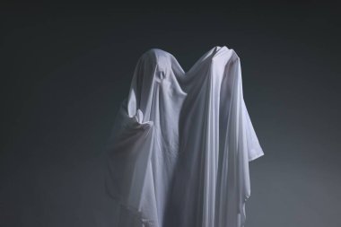 Ürkütücü hayalet. Açık gri arka planda beyaz çarşaflı adam