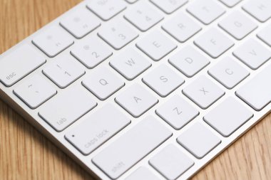 Modern beyaz kablosuz klavye ahşap masada, yakın plan