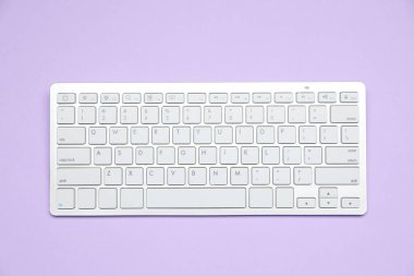 Menekşe arkaplan üzerinde beyaz kablosuz klavye, üst görünüm