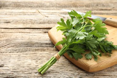 Tahta masada maydanoz ve bıçak var, yakın plan. Metin için boşluk