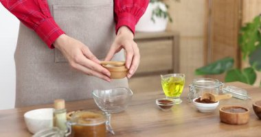 Tahta masada doğal vücut ovucu yapan kadın, yakın plan.