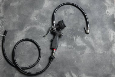 Gri arka planda göstergesi olan bir lastik enflasyon silahı.