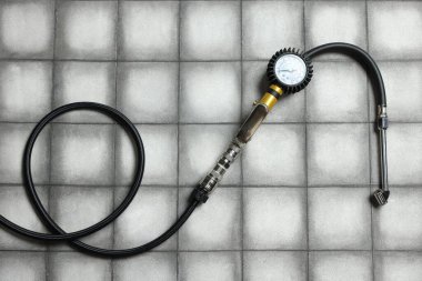 Işıklı arka planda göstergesi olan bir lastik enflasyon silahı, üst görünüm.