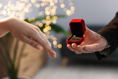 Nişan yüzüklü bir adam içeride kız arkadaşına evlenme teklif ediyor, yakın plan. Bokeh etkisi