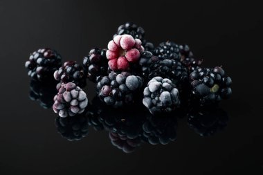 Birçok olgun donmuş böğürtlen siyah masada