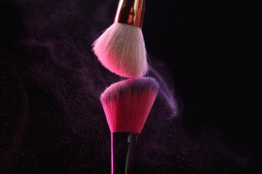 Siyah arkaplanda renk farlı makyaj fırçaları, yakın plan