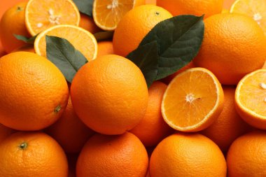 Arkaplan olarak sulu portakallar ve yeşil yapraklar, yakın plan