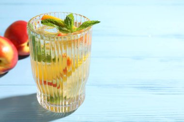 Şeftalili buzlu çay ve açık mavi ahşap masada nane şekeri, yakın plan. Metin için boşluk