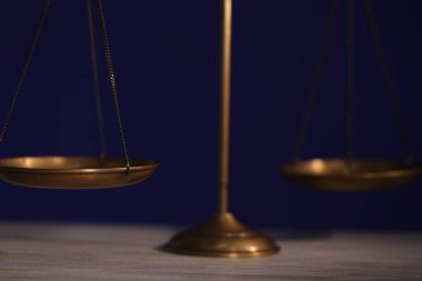 Adaletin terazisi ahşap masada, karanlık arka planda, yakın planda