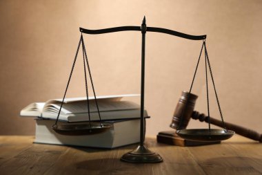 Adalet terazileri, tokmak ve ahşap masa üzerindeki kitaplar bej arka plan, seçici odak