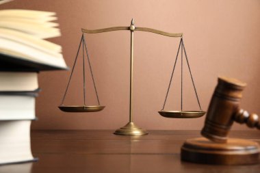 Adaletin terazisi, tokmak ve tahta masa üzerindeki kitaplar, seçici odaklanma.